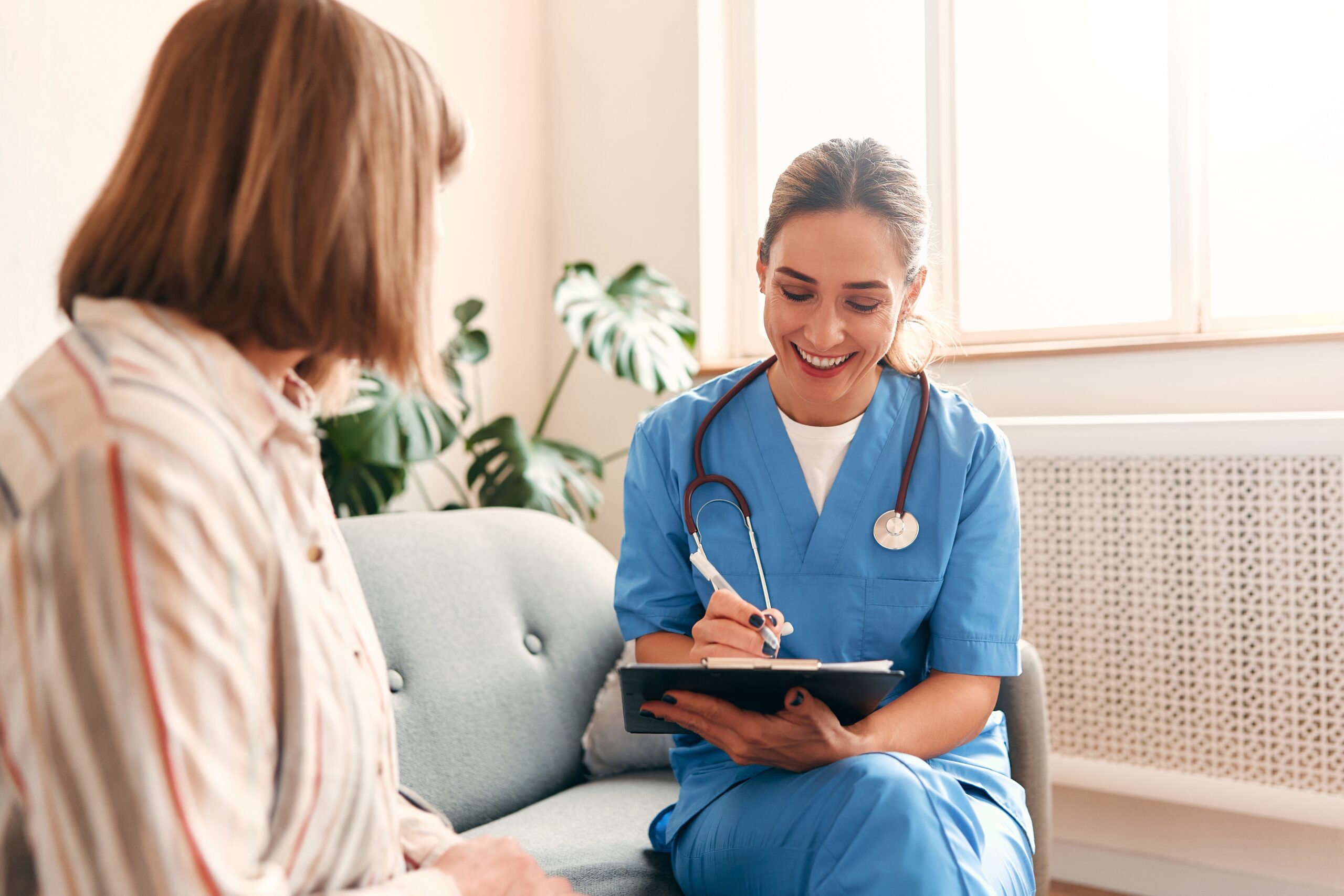 Nurse speaking with a mother at home about preparing for her child’s tracheostomy care.