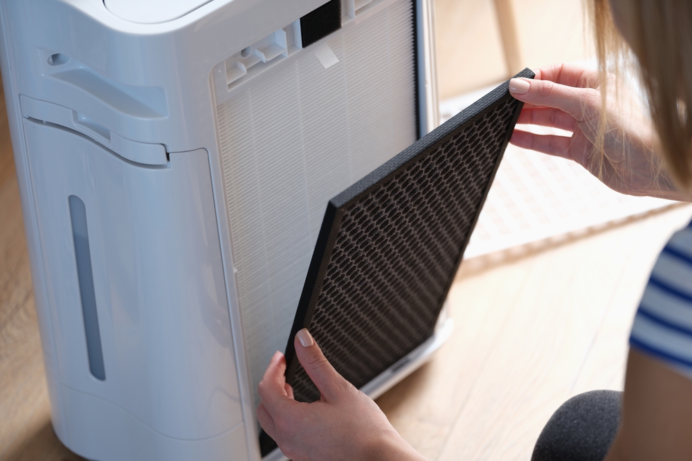 Caregiver changing a filter at home to support indoor air quality for respiratory health.